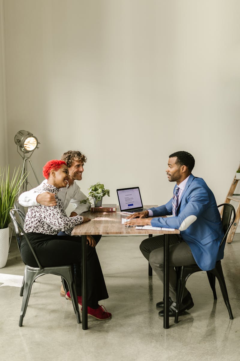 Business loan agent discussing options with two clients in a professional setting.